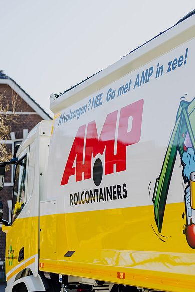 Zijkant van een AMP-vrachtwagen met opvallende slogan en kleurrijke illustratie van een afvalcontainer.