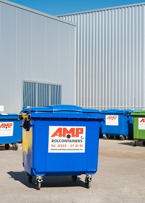Verschillende maten containers staan buiten voor een loods.