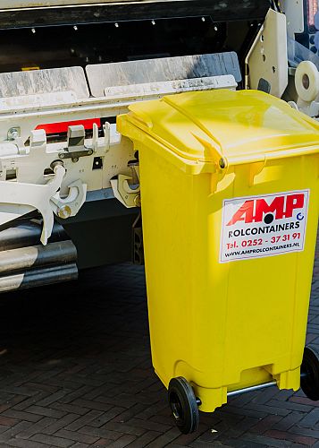 Gele AMP-rolcontainer staat klaar bij de achterkant van de inzamelwagen tijdens een reguliere ophaalronde in het dorpscentrum.
